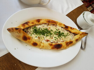 Traditional Turkish Cuisine Kasarli Pide boat-shaped flatbread with cheese, spices and herbs