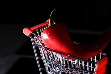 red pepper and shopping cart on black background