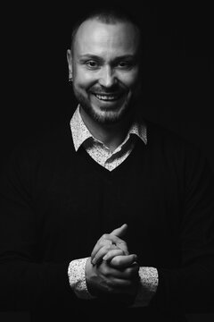 Fabulous at any age. Portrait of charismatic 40-year-old man standing over black background and laughing. Short haircut. Classic, smart casual style. Black and white studio shot