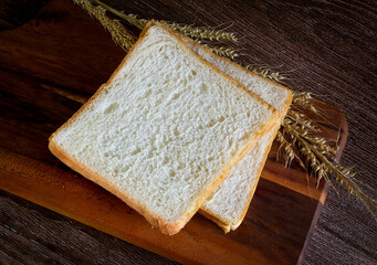 Fototapeta na wymiar piece of bread lying on the wooden floor Dark wood background