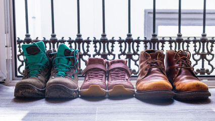 Shoes of two men and a girl on a balcony door. Family everyday life concept. Gay families, two...