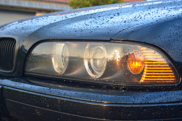 BMW e39 Scheinwerfer mit Blinker Front mit Motorhaube mit Regentropfen im Sommer - obrazy, fototapety, plakaty