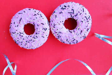 Two bright donuts on a pink background. A party.