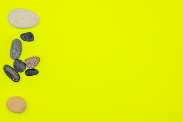 Fototapeta na wymiar Layout of sea pebbles on a yellow background