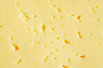 Emmentaler Käse mit Löchern als Nahaufnahme. Gelber Hintergrund zum Thema Essen.