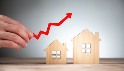 man holding house models and arrow