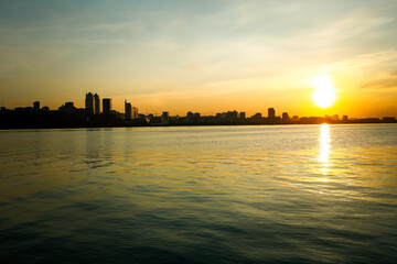 City embankment at sunset. Dnepr River the fourth longest in Europe. Shimmering sunlight on ripples...