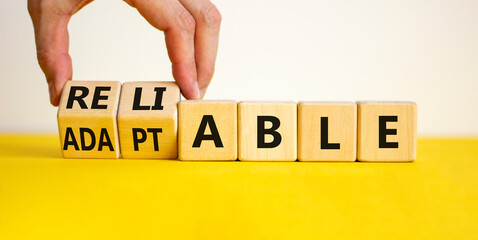 Adaptable or reliable symbol. Businessman turns wooden cubes and changes the word adaptable to reliable. Beautiful white background, copy space. Business and adaptable or reliable concept.