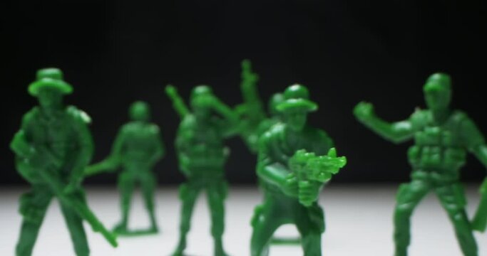 detailed extreme close-up plastic green toy soldiers arranged on black background.