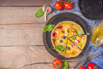 Homemade quiche Lorraine , savory pie with salmon fish, broccoli, spinach and tomatoes, on wooden table background copy space