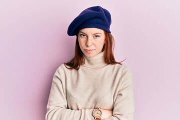 Young red head girl wearing french look with beret skeptic and nervous, disapproving expression on...