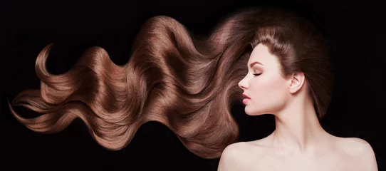 Foto auf Acrylglas Braune Haare. Schöne junge Frau mit gesunden luxuriösen langen Haaren auf dunklem Hintergrund. Frisur. Haarkosmetik © Jukov studio