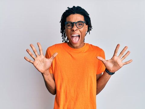 Young african american man wearing casual clothes and glasses celebrating crazy and amazed for success with arms raised and open eyes screaming excited. winner concept