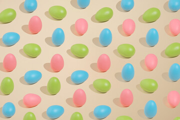 Playful pastel Easter pattern made of pink, green and blue eggs on beige background. Minimal concept style.