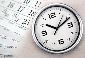 large white clock face with calendar sheets