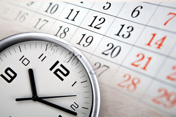 large white clock face with calendar sheets