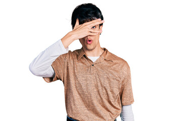 Handsome hipster young man wearing 90s retro style peeking in shock covering face and eyes with...