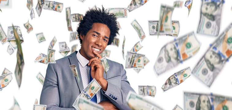 Handsome african american man with afro hair wearing business jacket looking confident at the camera smiling with crossed arms and hand raised on chin. thinking positive.