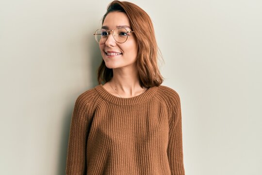 Young caucasian woman wearing casual clothes and glasses looking to side, relax profile pose with natural face and confident smile.