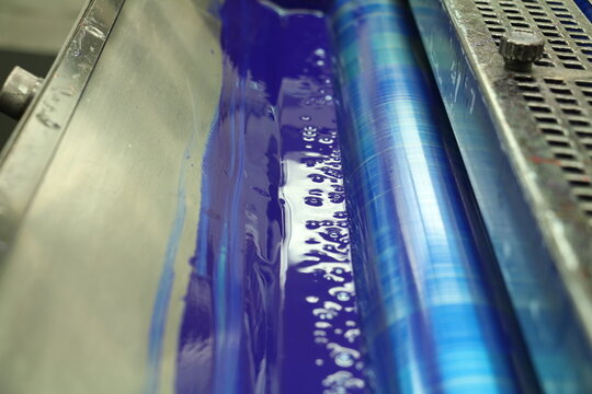 The blue painted roller system of the printing machine in Matbaa. Komori lithrone. selective focus