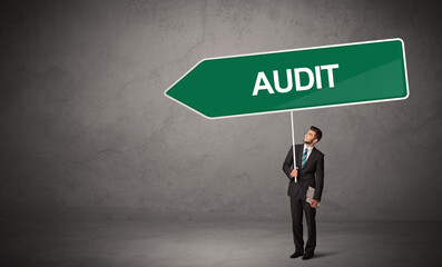 Obraz premium Young business person in casual holding road sign