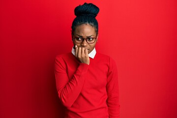 Young african american woman wearing casual clothes and glasses looking stressed and nervous with hands on mouth biting nails. anxiety problem.