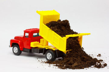 Toy dump truck  unloading agricultural  fertile soil and compost