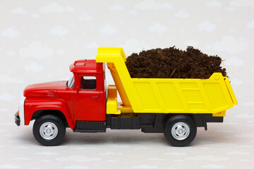 Toy dump truck carring agricultural fertile soil and manure 