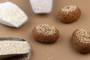A healthy gluten-free keto bread made from almond flour and psyllium husk, sprinkled with sesame seeds. Baking ingredients in scoops. Ketogenic diet, paleo, low carb, high fat.