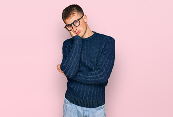 Young blond man wearing casual clothes and glasses thinking looking tired and bored with depression problems with crossed arms.