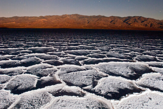 Salt patterns at dusk and full moon light over Badwater, -282 feet below sea level in Death Valley National Park, California.