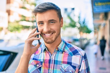 Young caucasian man smiling happy talking on the smartphone at the city.