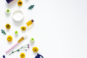 Wellness cosmetics background frame, mock up, top view, copy space. Natural cosmetic ingredients, flowers, herbs, oils, cream, bottles on a white background