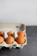  brown eggs close-up on a dark background in the package