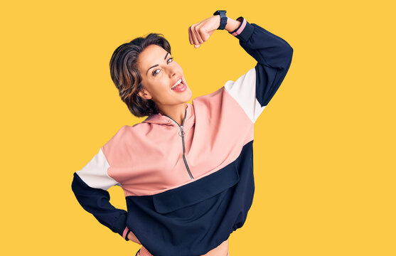 Young beautiful woman wearing sportswear strong person showing arm muscle, confident and proud of power