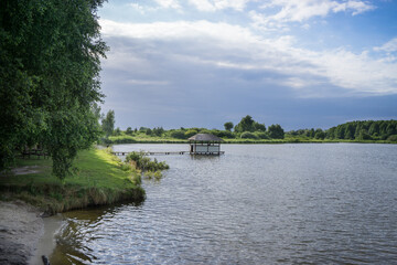 A wooden house with a thatched roof on the water surface of the lake.