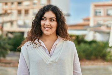 Young hispanic woman smiling happy standing at the city.