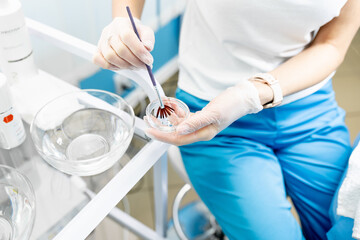 A female hands of a beautician with a brush. Facial skincare.  woman on a cosmetology procedure