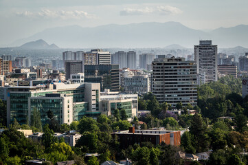 Skyline of modern buildings at financial district with The Andes mountain range in the back.