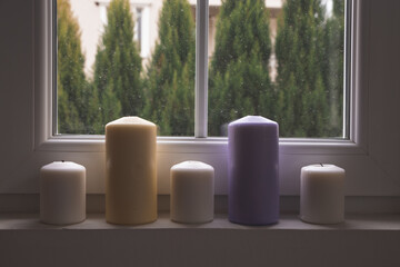 Colorful Candles next to a window with spring view