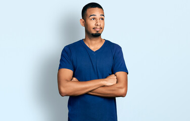 Young african american man with arms crossed gesture smiling looking to the side and staring away thinking.