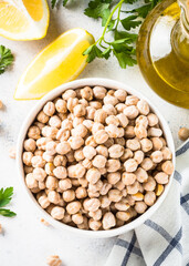 Chickpeas in white bowl at light kitchen table.