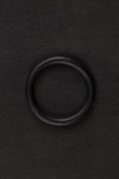Erection ring on black leather background.