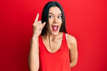 Young hispanic girl wearing casual style with sleeveless shirt pointing finger up with successful...
