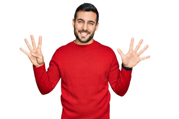 Young hispanic man wearing casual clothes showing and pointing up with fingers number nine while smiling confident and happy.