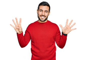 Fototapeta premium Young hispanic man wearing casual clothes showing and pointing up with fingers number nine while smiling confident and happy.