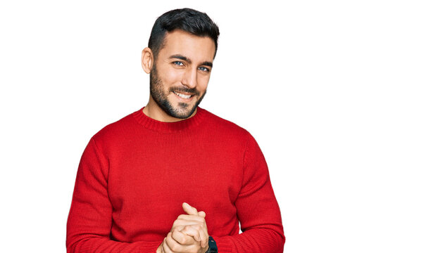 Young hispanic man wearing casual clothes with hands together and crossed fingers smiling relaxed and cheerful. success and optimistic