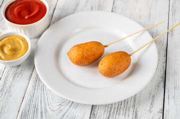 Corn dogs on white serving plate