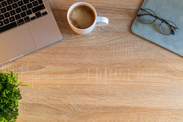 Escritorio de trabajo Moderno, con portátil, gafas, café y hojas verdes. Escritorio o mesa en blanco para poner el texto en el medio.