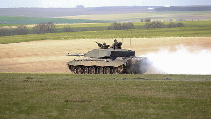 a british army Challenger II 2 FV4034 main battle tank throws out a smoke screen, in action on a...